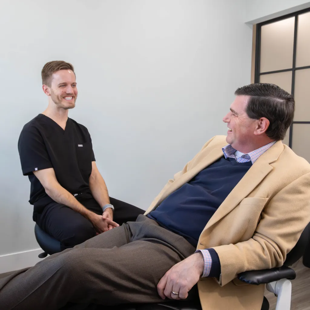 Man with beard flossing his teeth in front of a mirror for oral hygiene.
