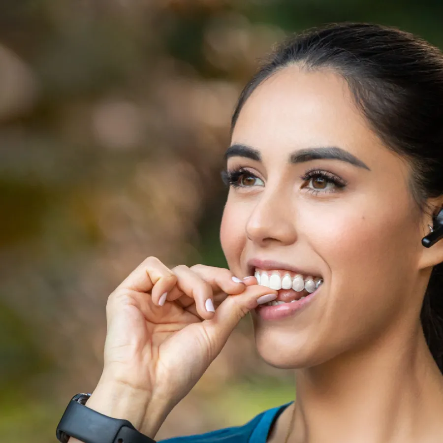 Clear Invisalign aligner against a blue background with Invisalign provider logo visible.