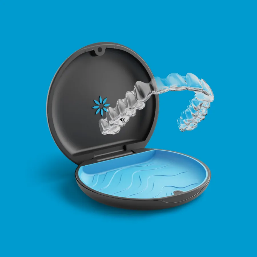 Clear dental aligner hovering above open black and blue storage case on blue background