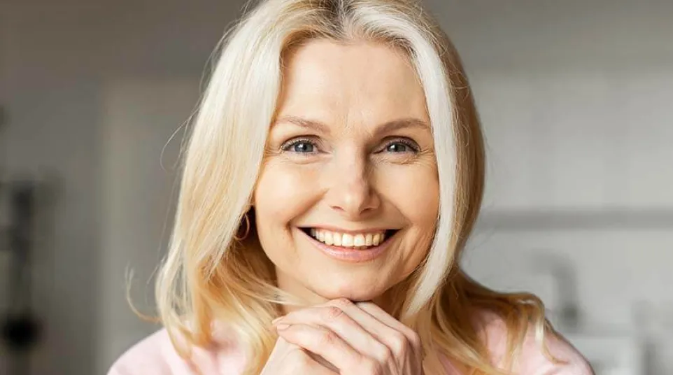 a woman smiling with her hand on her chin