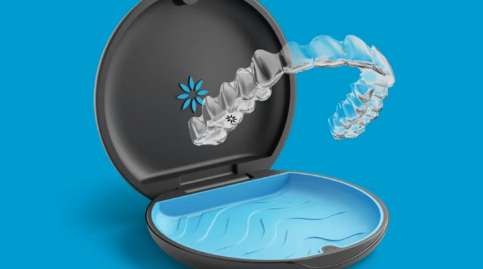 Clear dental aligner hovering above open black and blue storage case on blue background